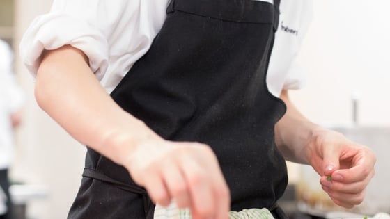 A catering student preparing some food in the kitchen