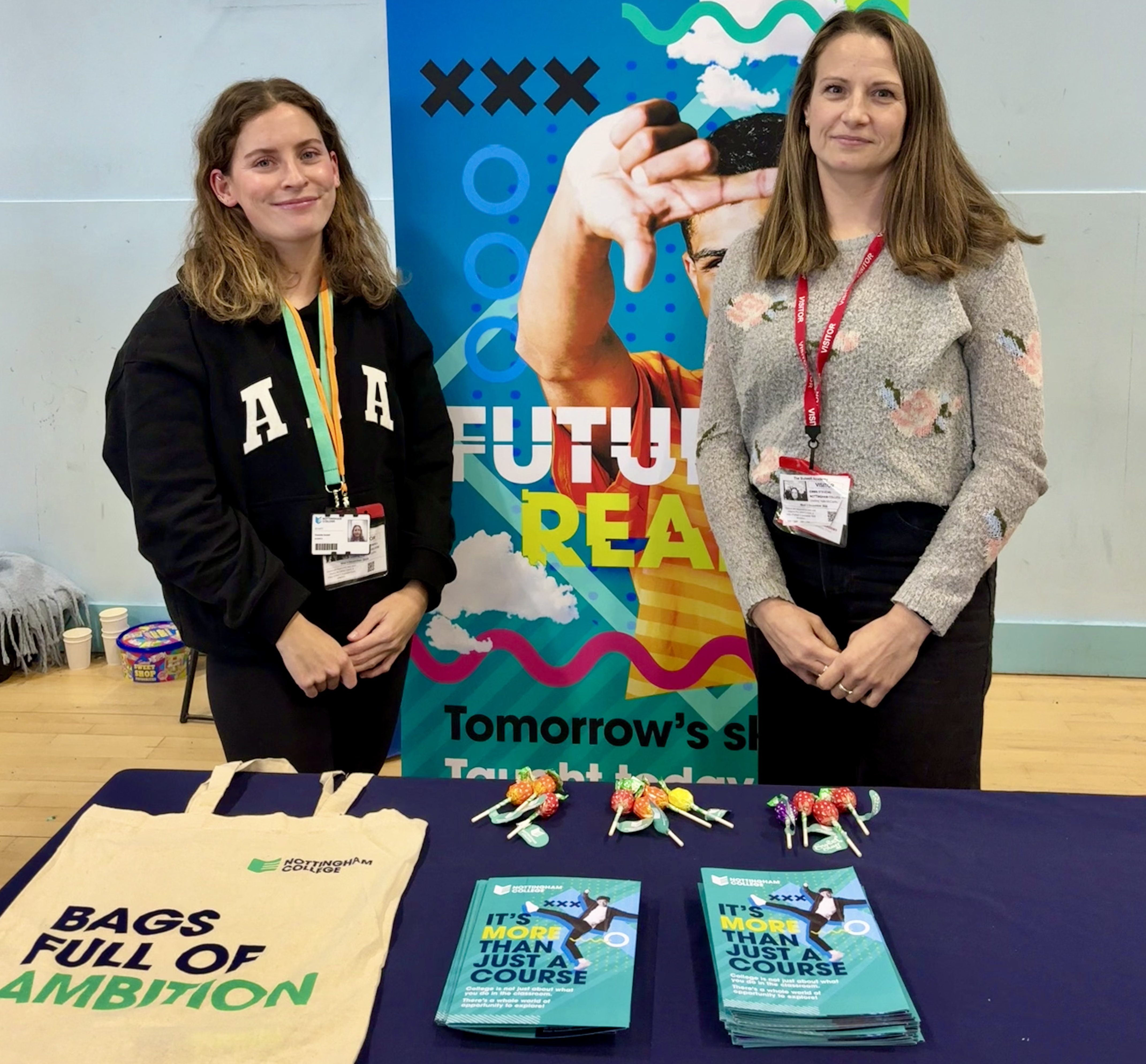 Two members of staff at a careers fair manning a Nottingham College stall