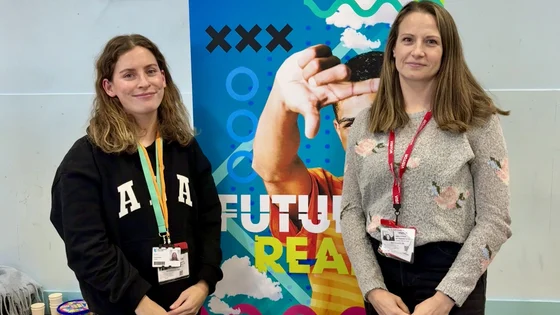 Two members of staff at a careers fair manning a Nottingham College stall