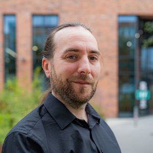 A member of staff stood smiling outside