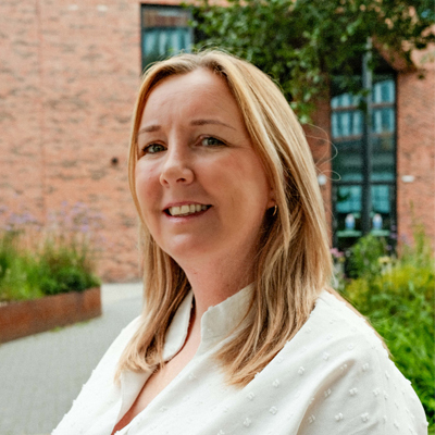 A member of staff smiling outside