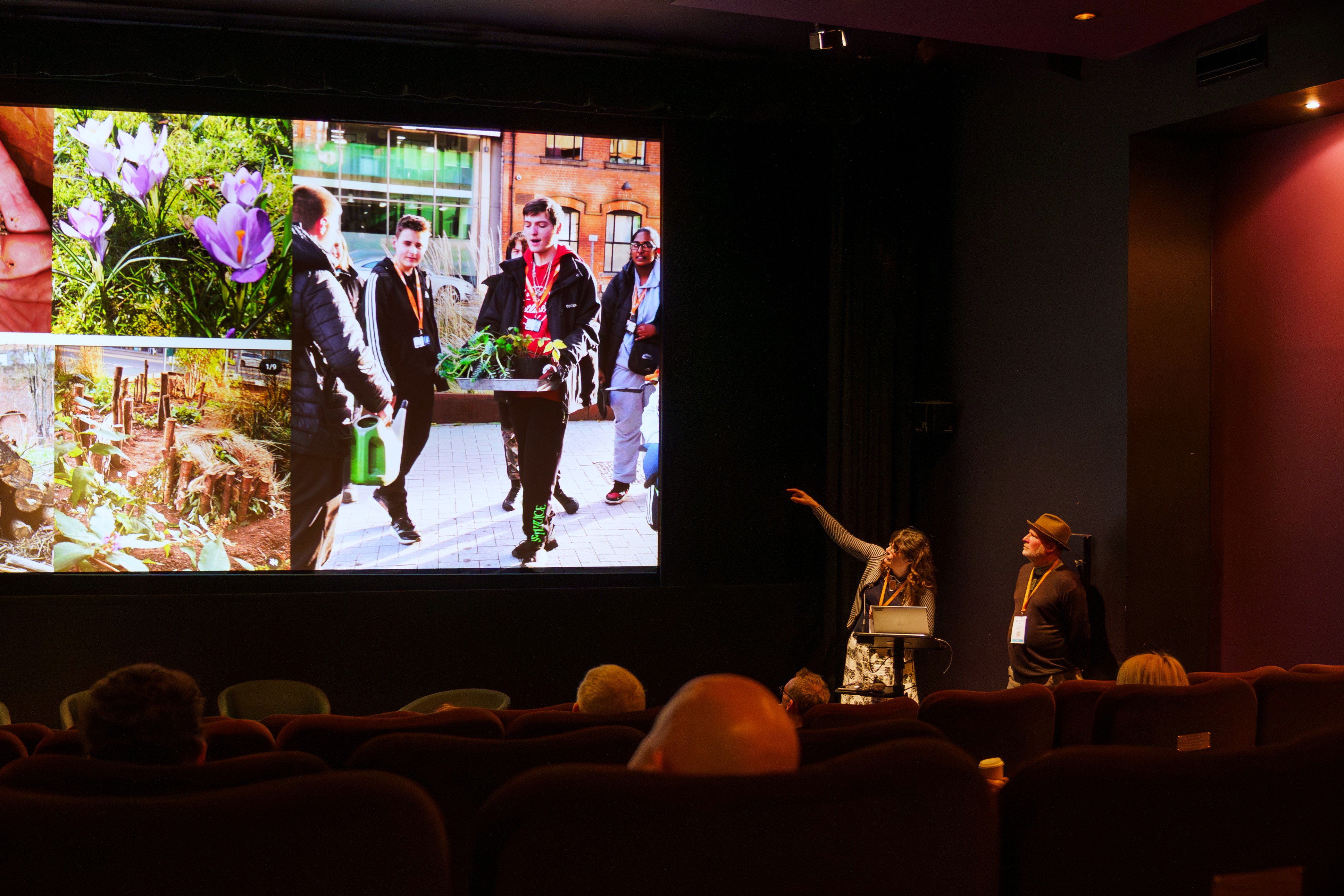 Matt and Liz can be seen on the right with Liz pointing towards a large screen. They are delivering a talk about their projects as part of FUTUREPROOF
