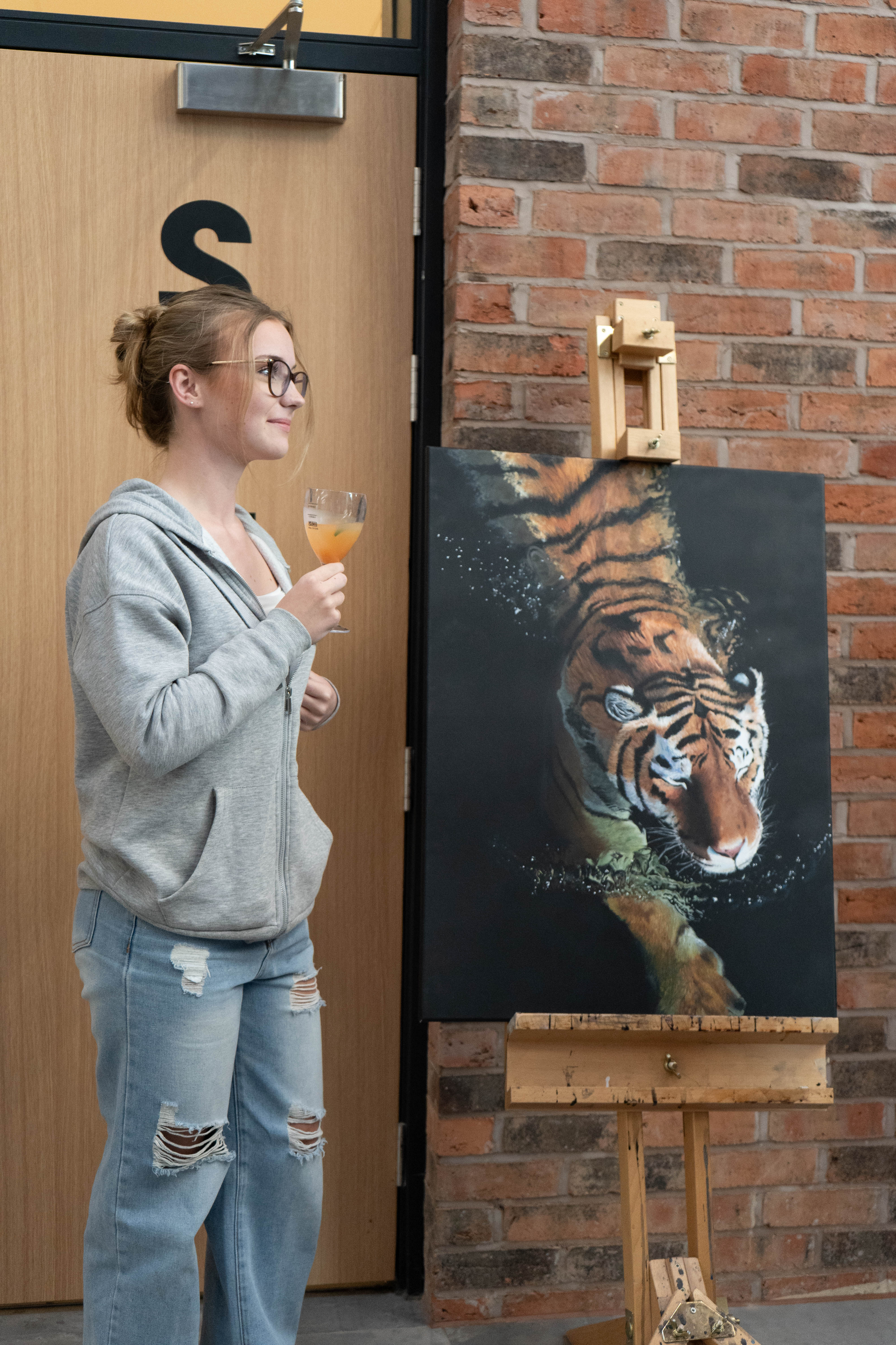 Young creative poses with their artwork