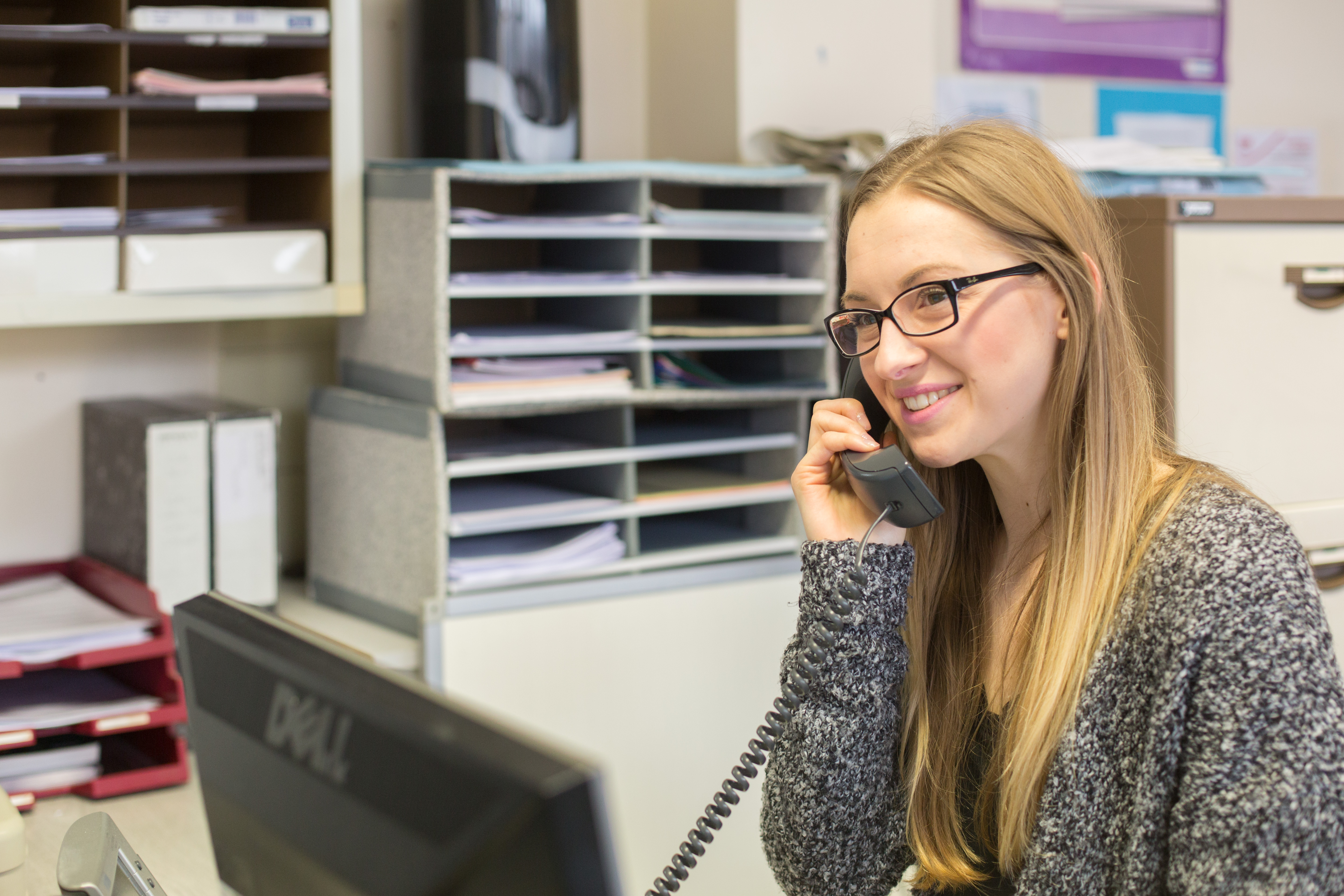 An apprentice answering the telephone in an office.