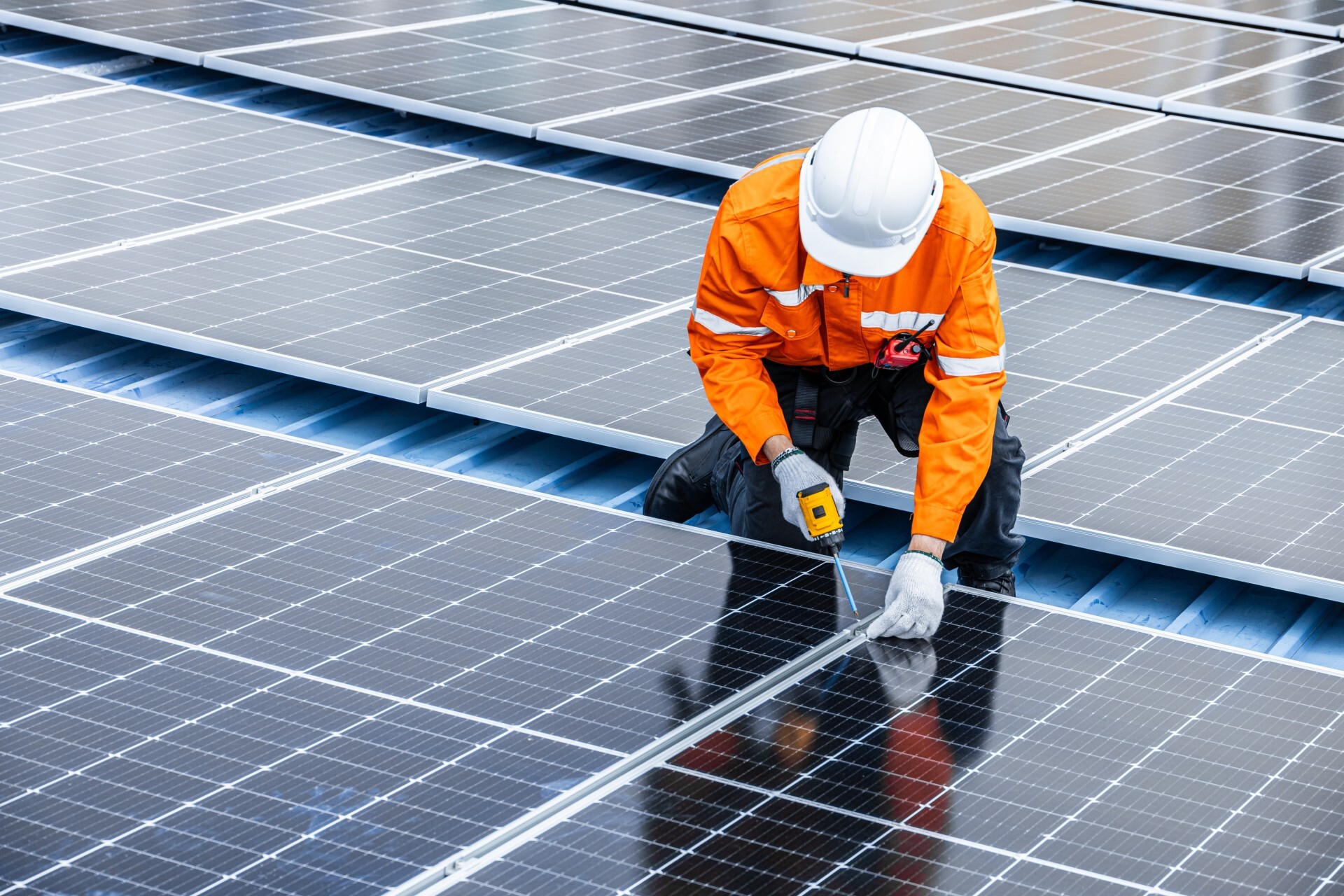 An engineer installing a solar panel on a roof