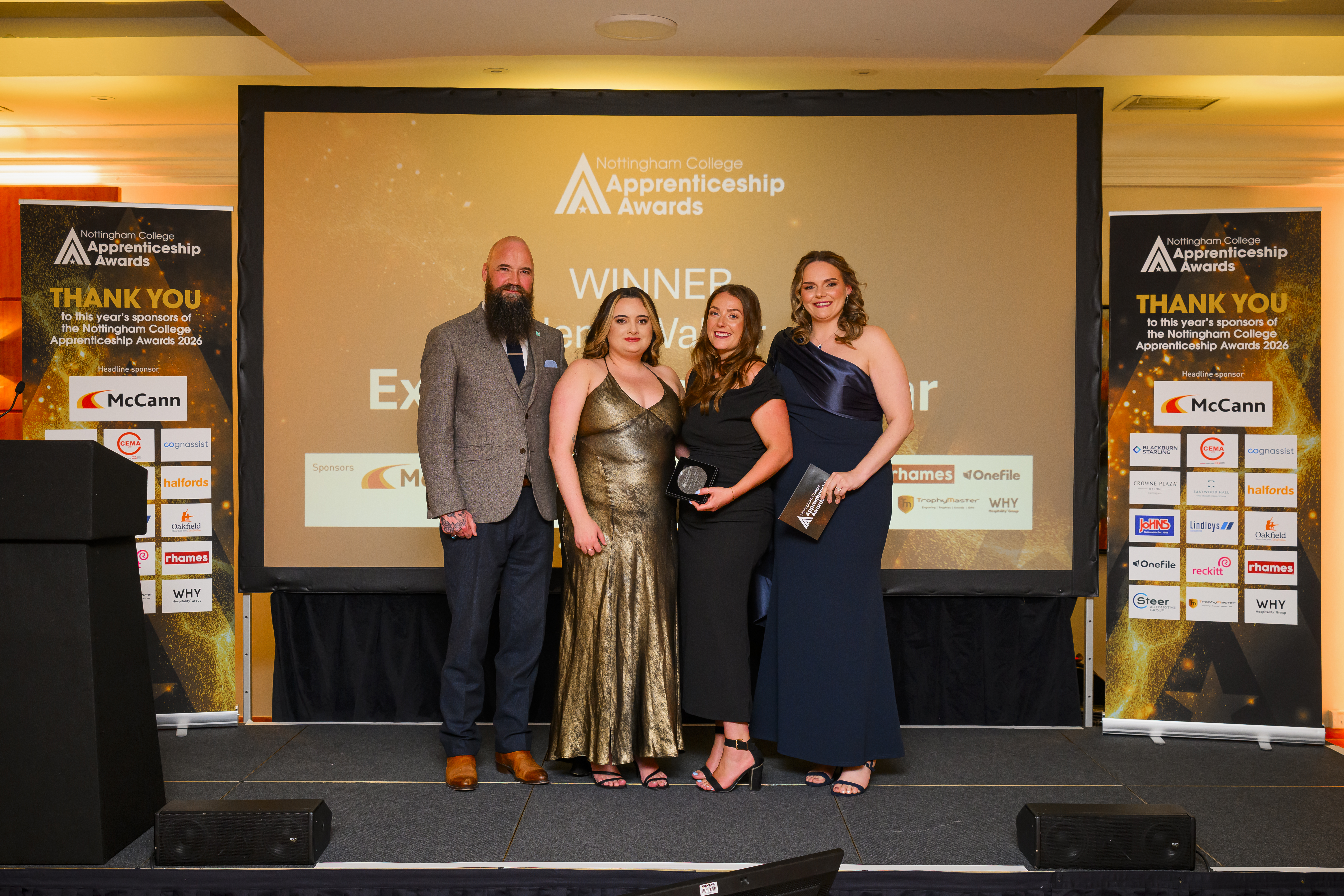 Jenni Walker on stage with her trophy, sponsor and Nottingham College hosts
