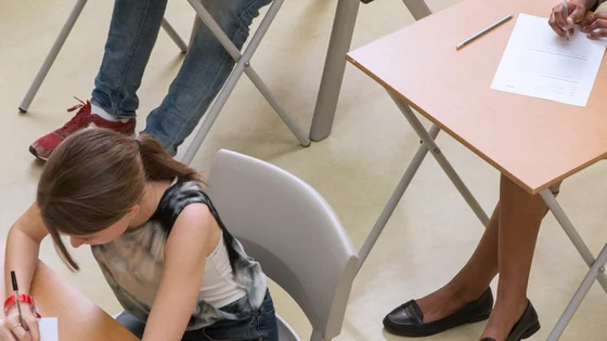 Students sat in an exam hall completing an exam