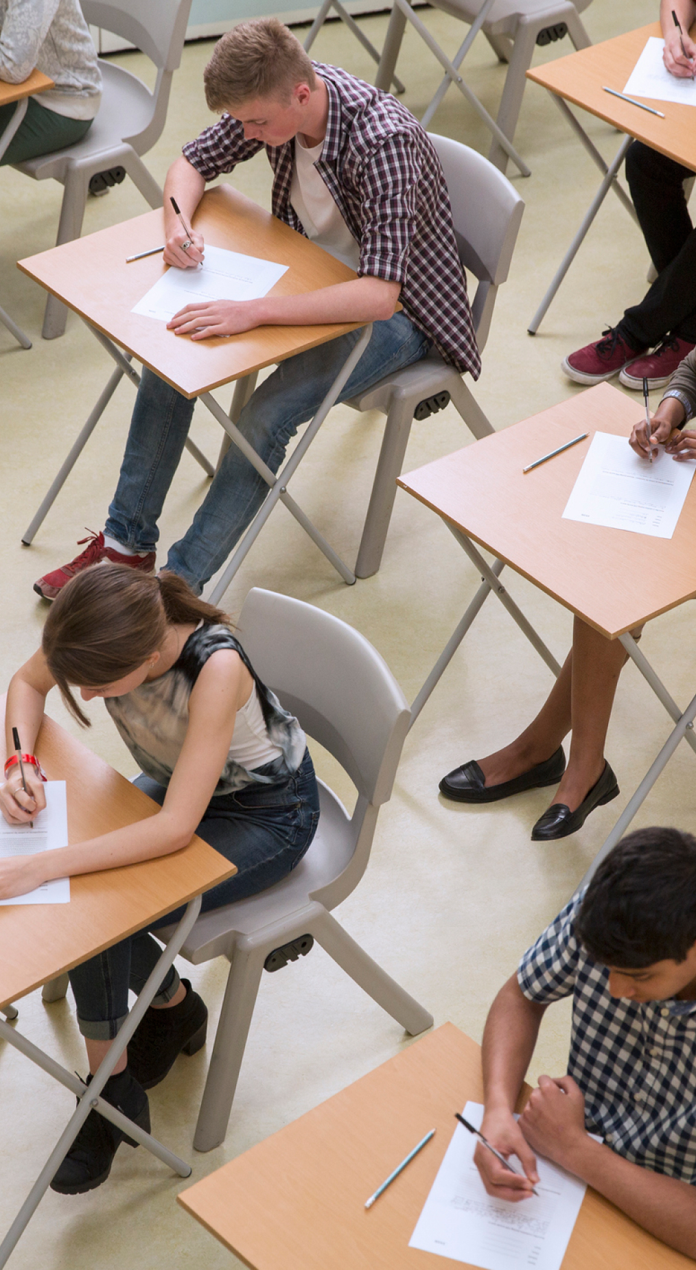Students sat in an exam hall completing an exam