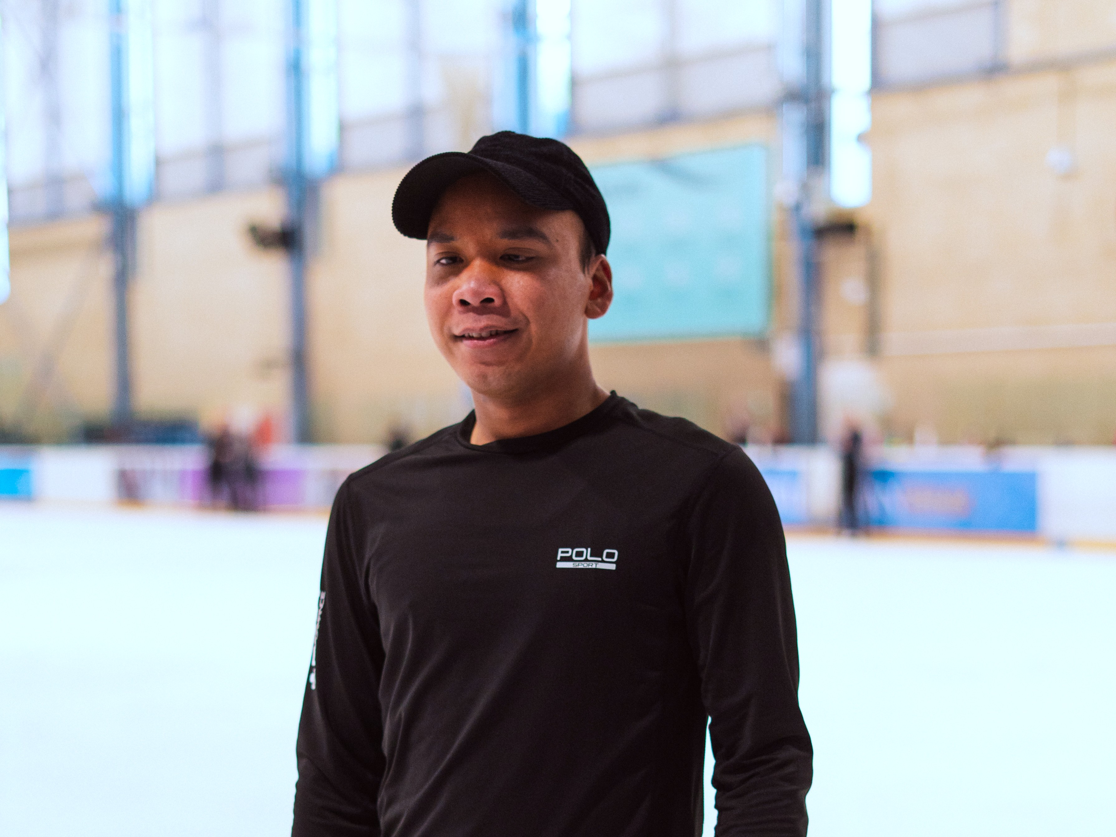 An image of Hanyu dressed in black standing in front of Nottingham's indoor ice rink.