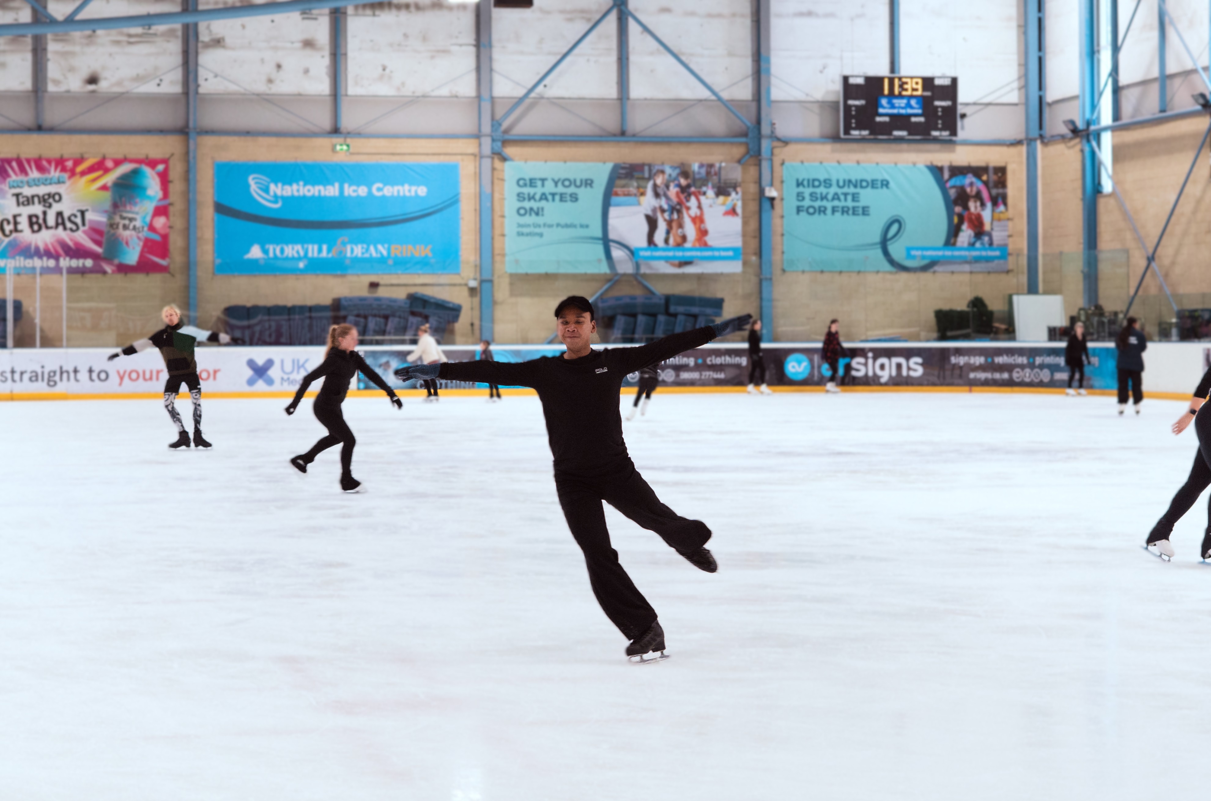 Photo of Hanyu with his arms out as he skates and twirls on the ice.