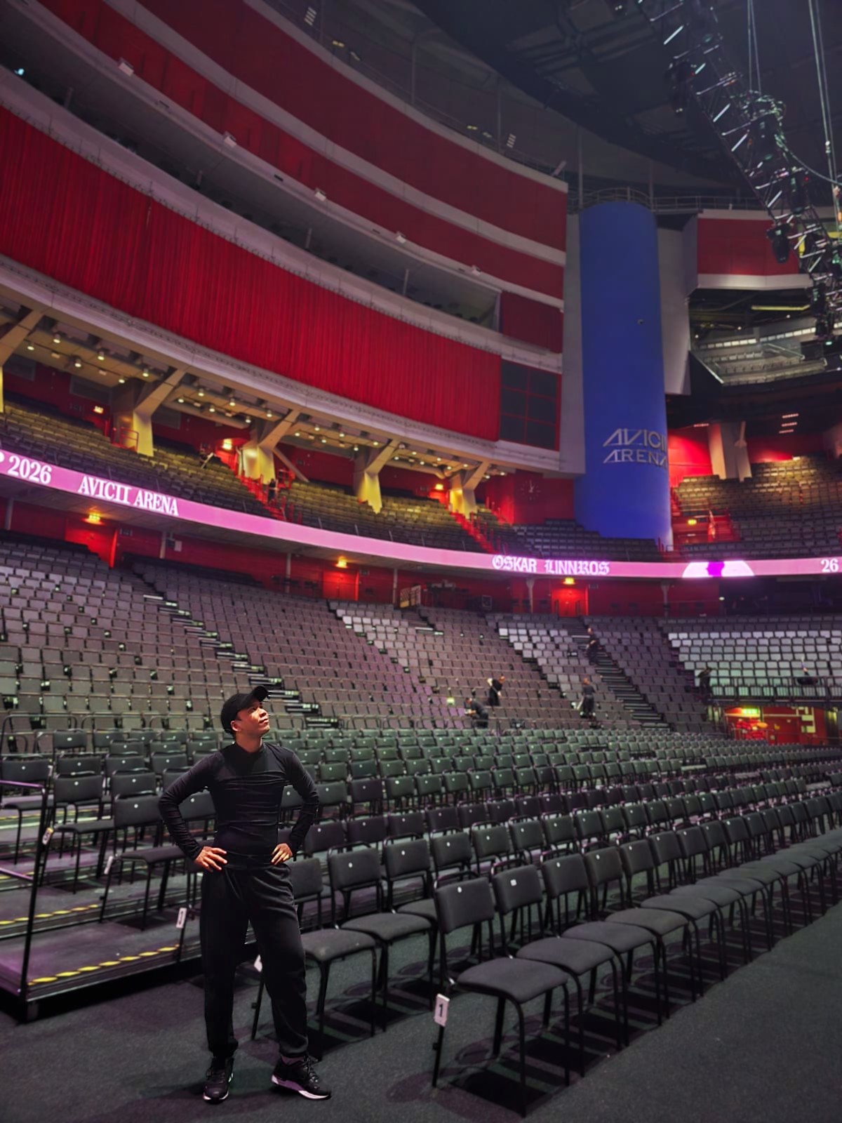 Hanyu poses triumphantly in front of a large arena of seating.