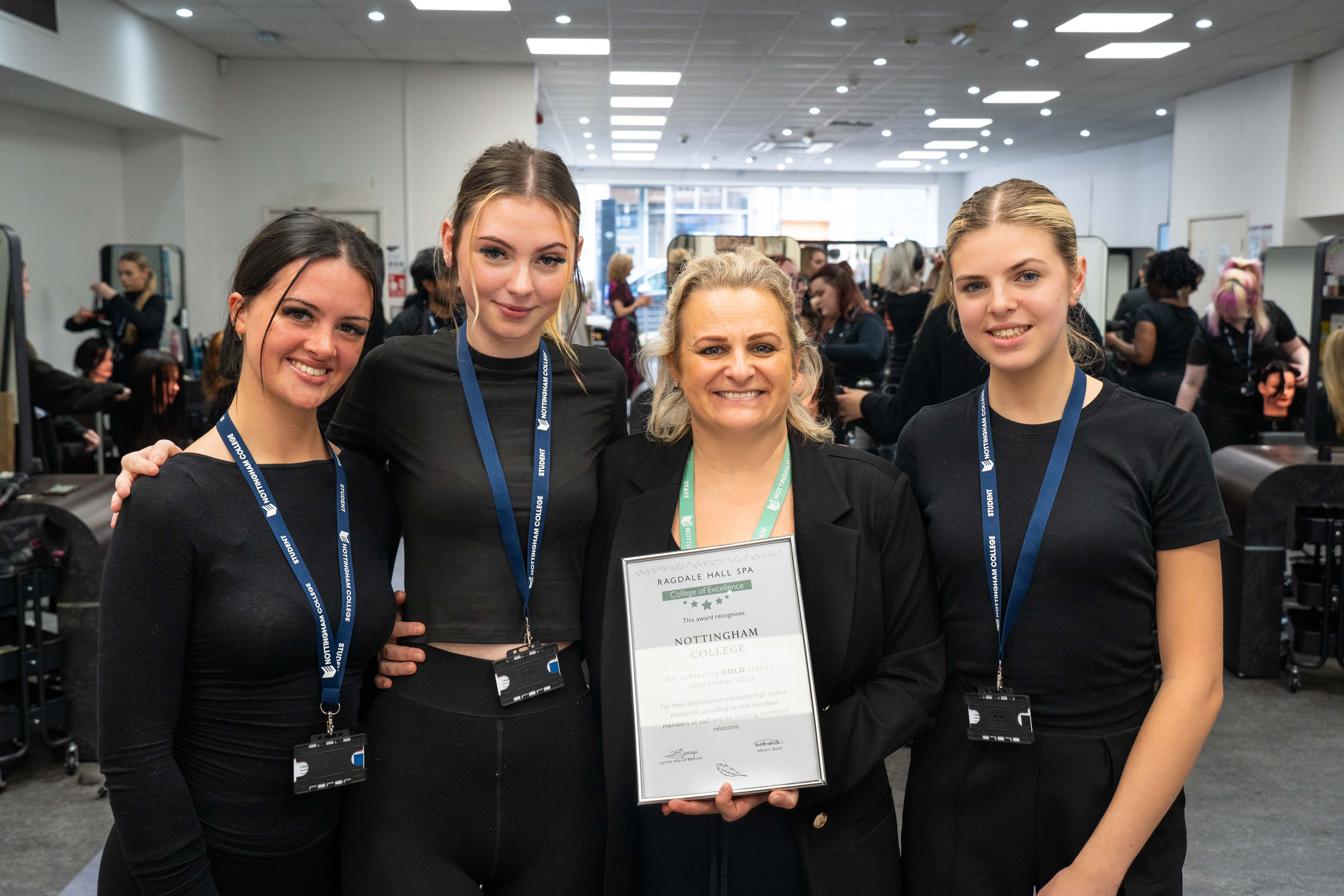 Three students and a tutor smiling with a certificate