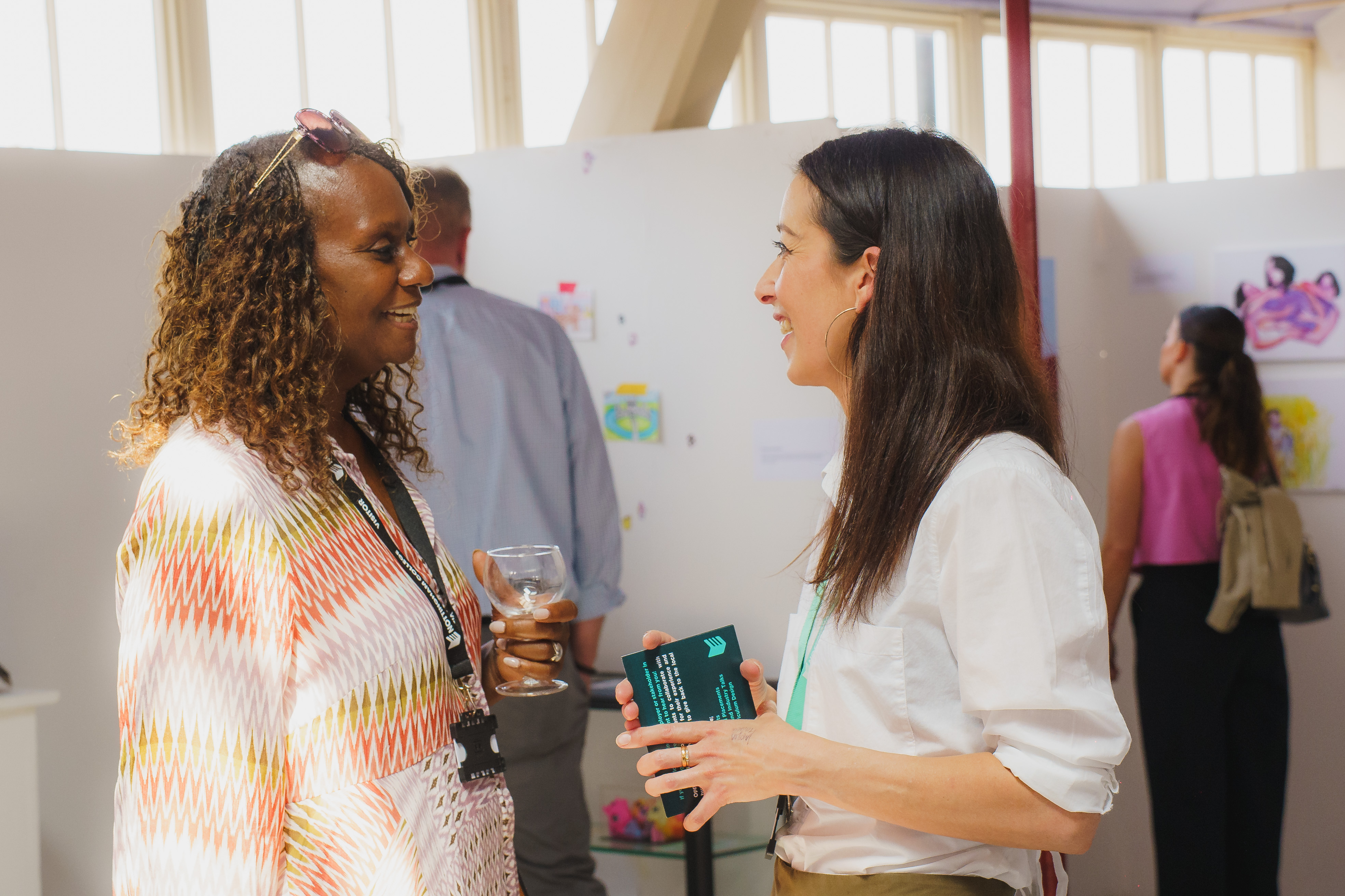 Guests talking in art gallery at Adams campus