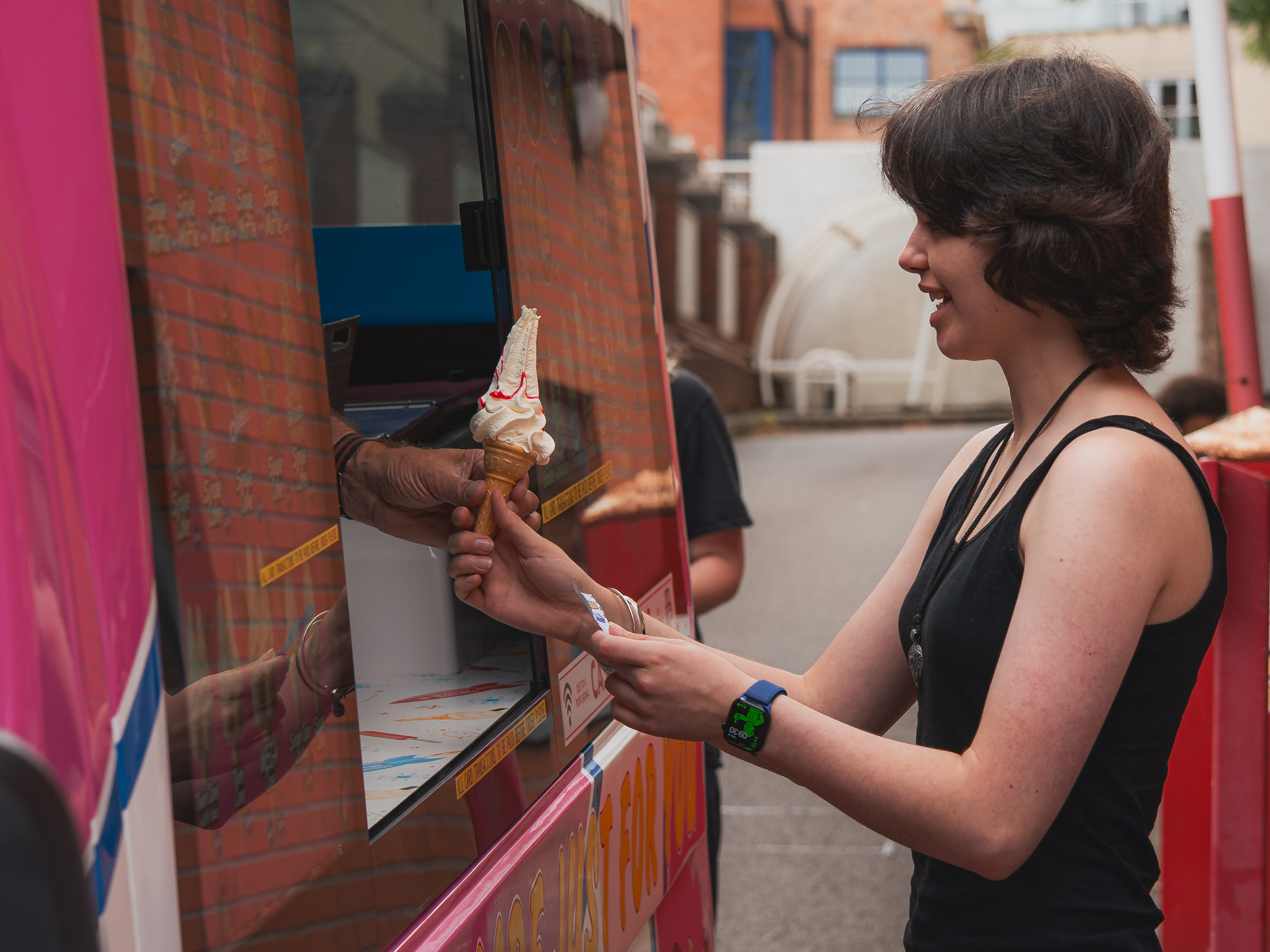 student receiving an ice cream from a truck