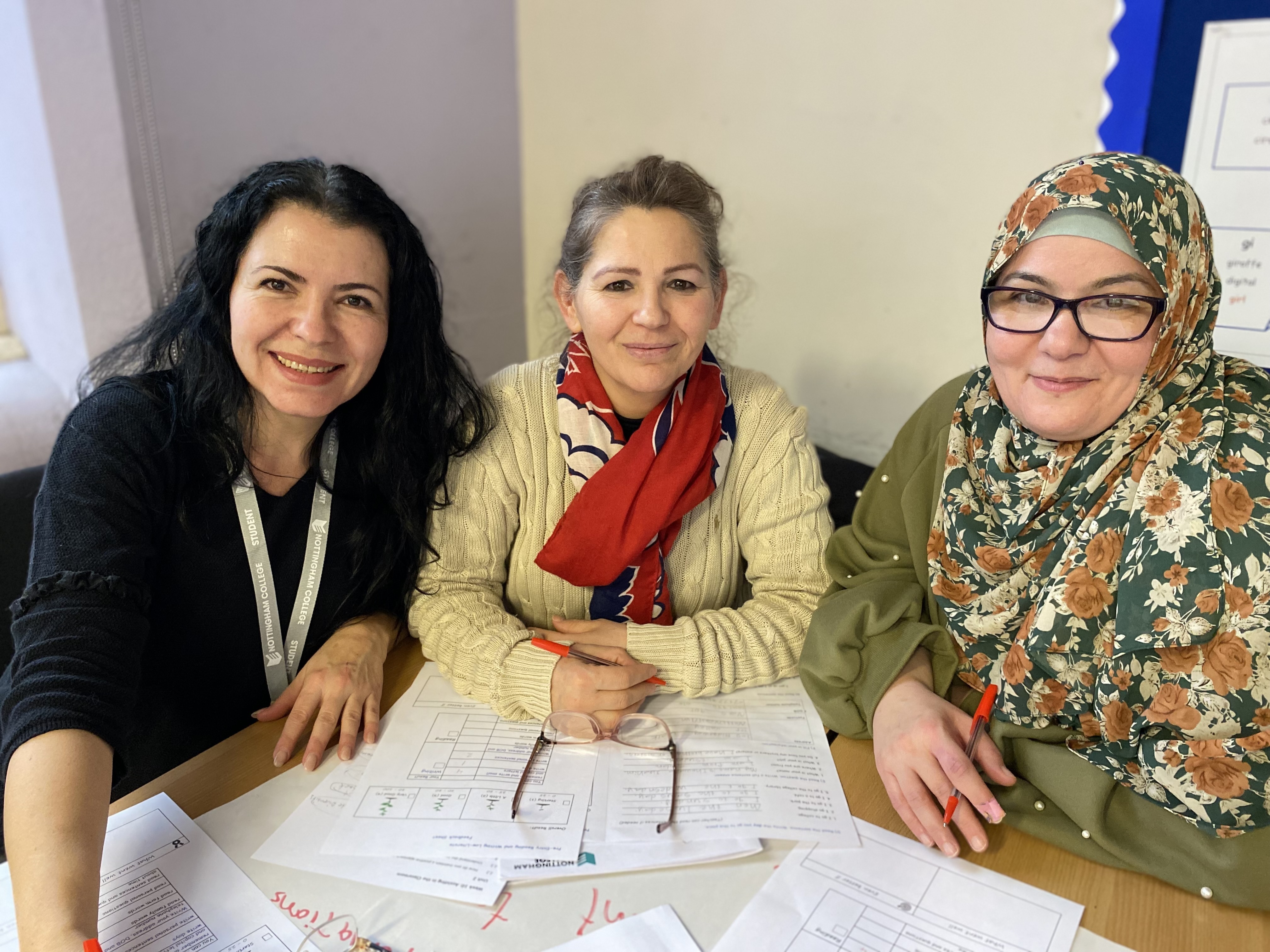 Three women sat together smiling