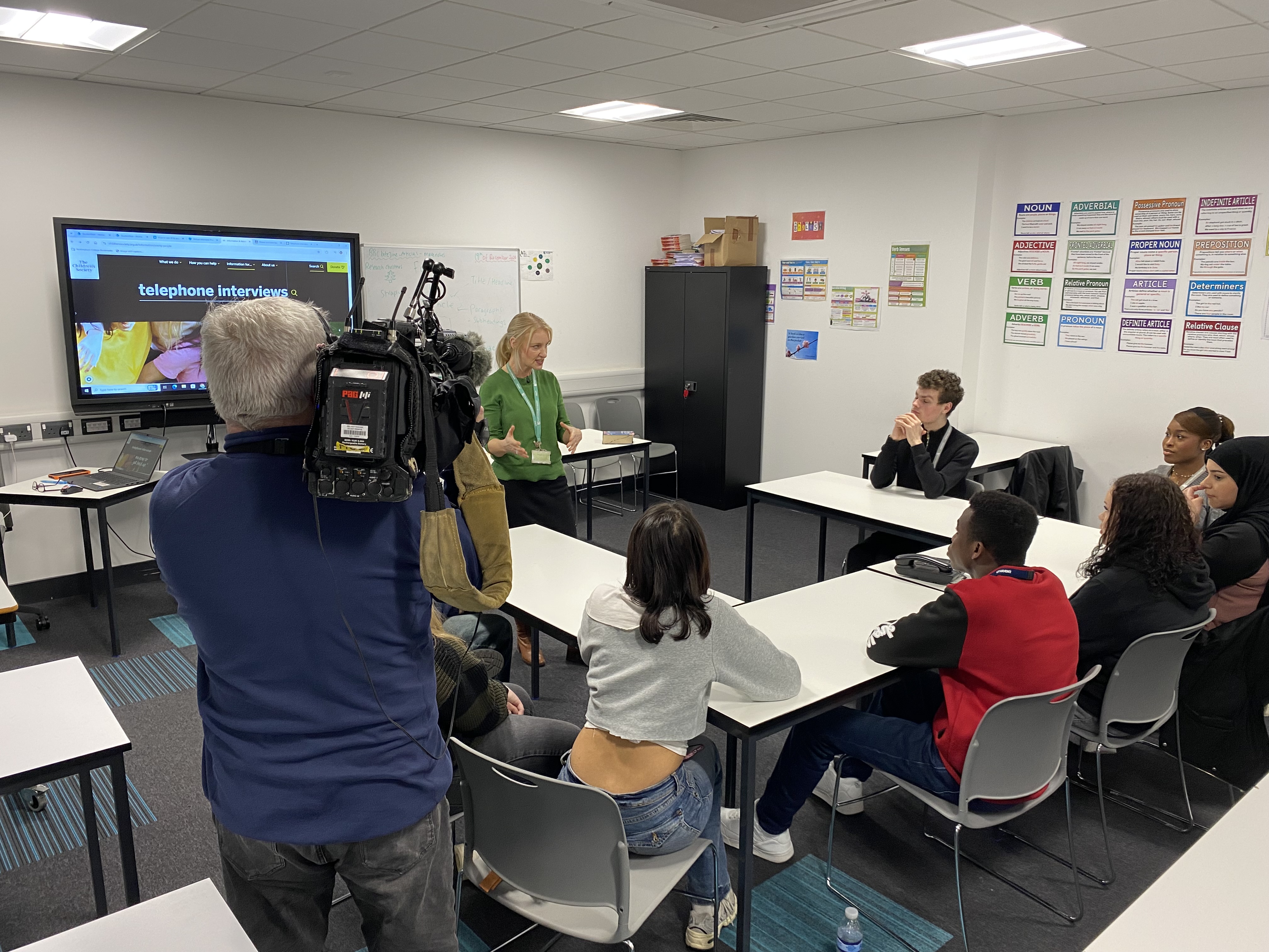 Teacher speaking to students while being filmed