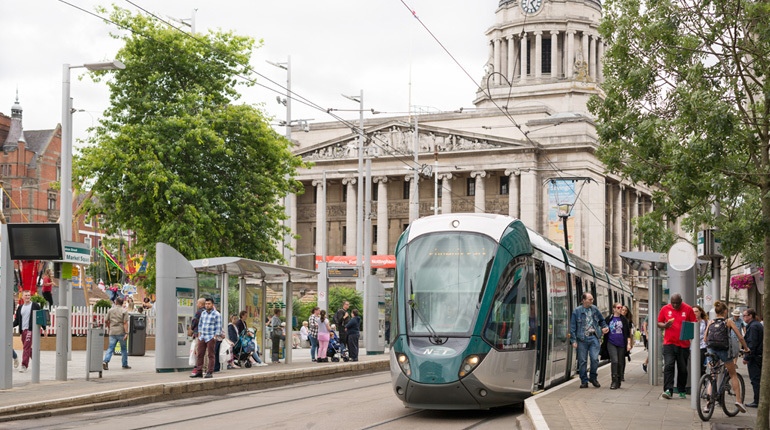 A picture of a tram in front of a council building in Nottingham City centre