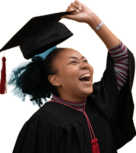 Picture of a smiling girl wearing graduation robes lifting her mortarboard off her head.