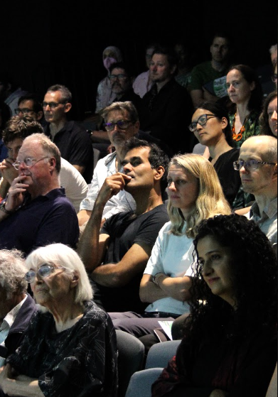 A group of audience members seated and looking in one direction.