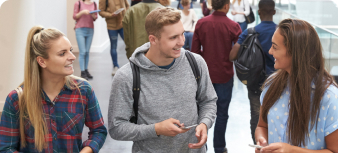 Three students walking in a corridor talking.