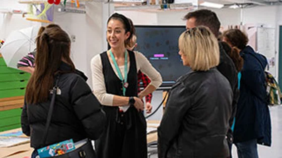 A member of staff talking to students at an open evening