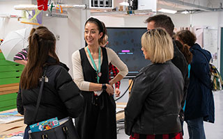 A member of staff talking to students at an open evening
