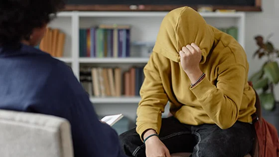 A student being helped by two members of staff at an open evening