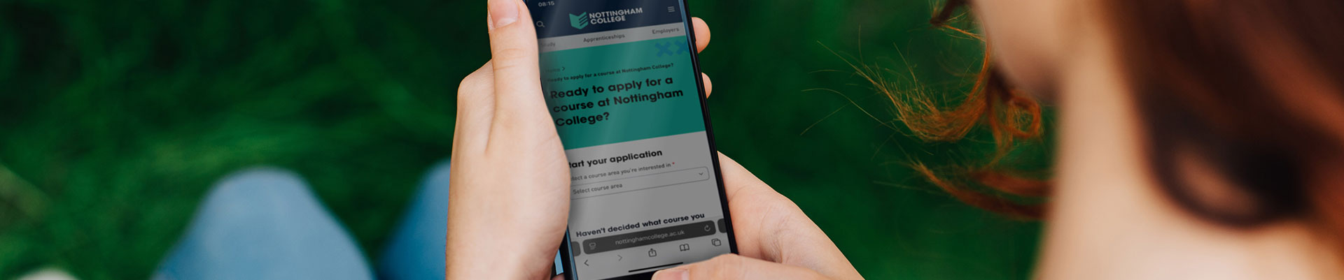 A person holding their phone looking at the application page on the Nottingham College website.