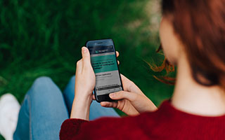 A person holding their phone looking at the application page on the Nottingham College website.
