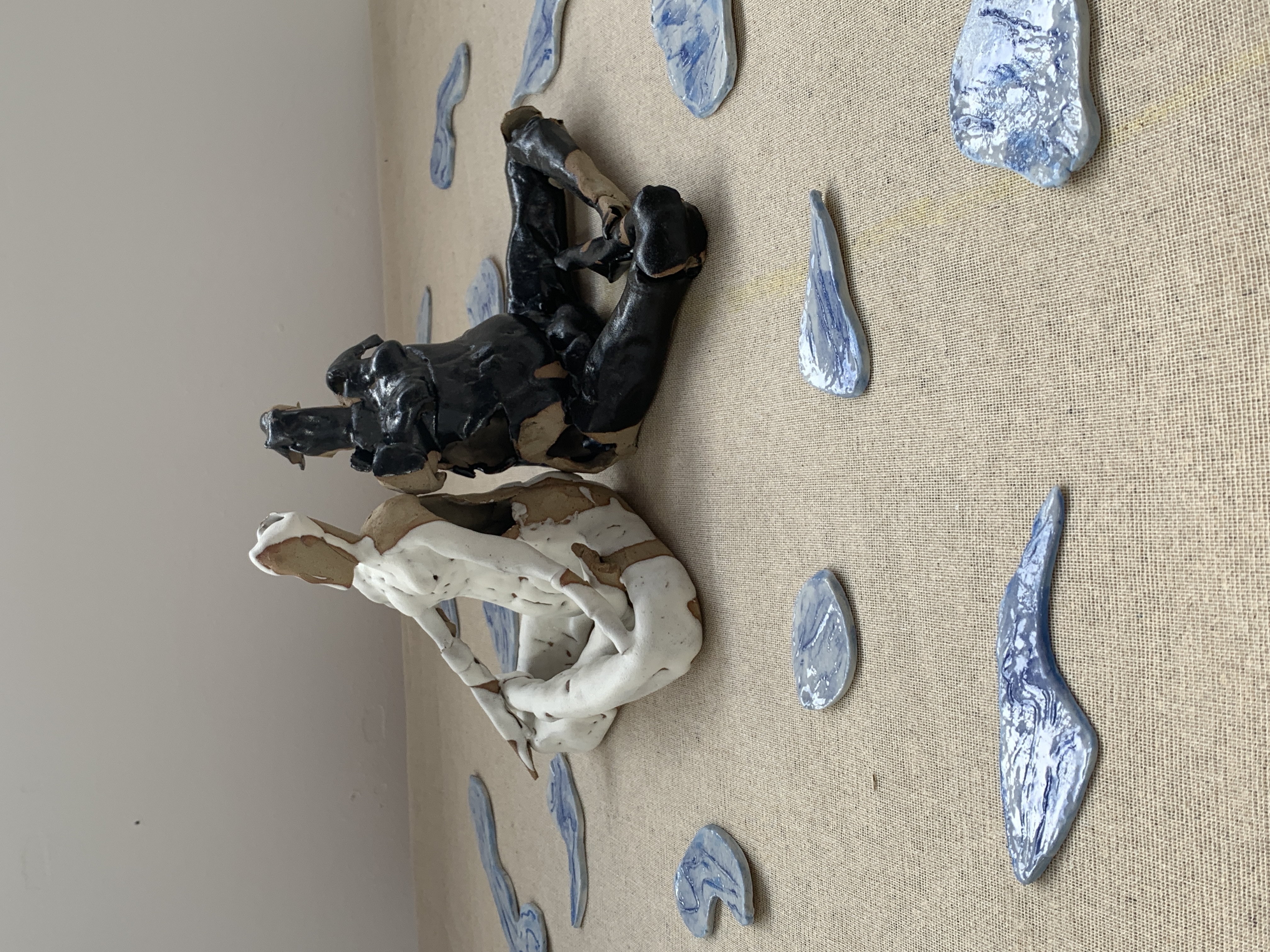 Sculpture of two figures with pieces around them