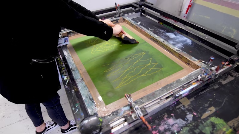 Student preparing artwork on a machine.