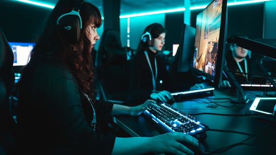 Two female students playing video games using professional equipment