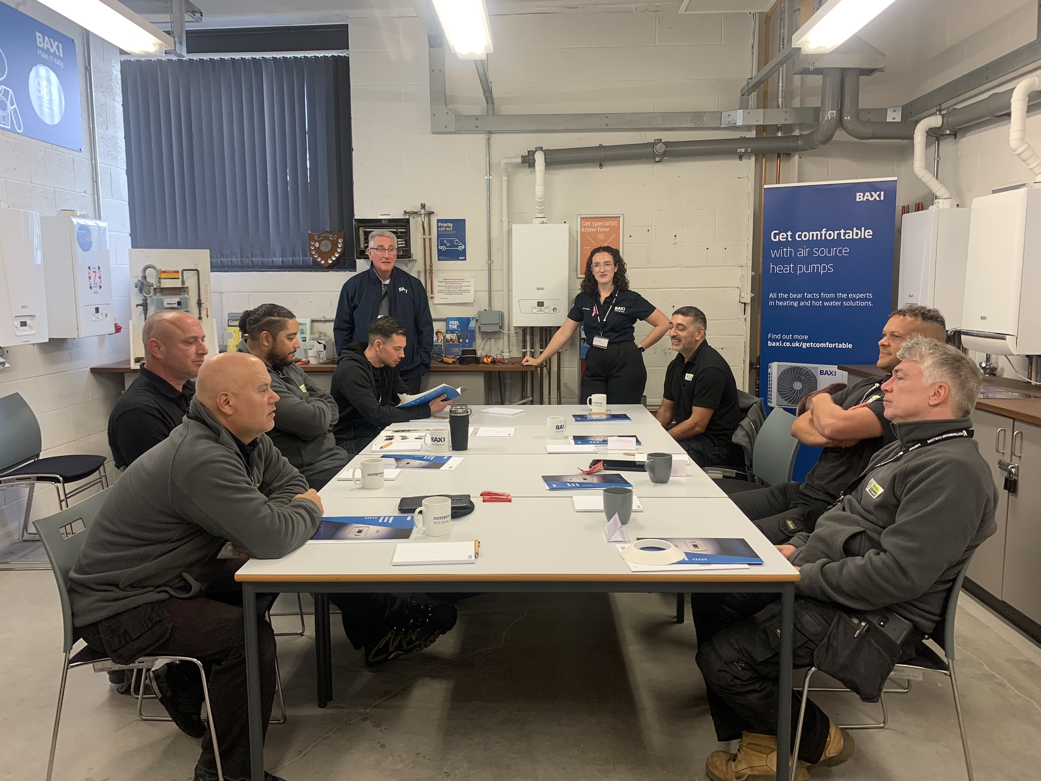 Adult learners sat in a classroom talking to each other and the tutor