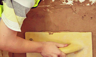 A student plastering a wall