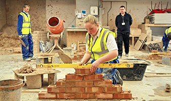 Students laying bricks in a workshop