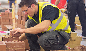 A student laying bricks