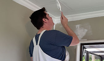 A person painting a ceiling.