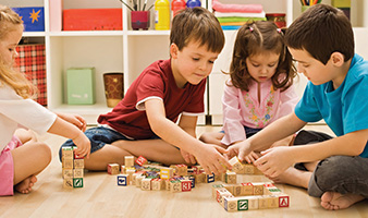 A group of children playing with wooden blocks