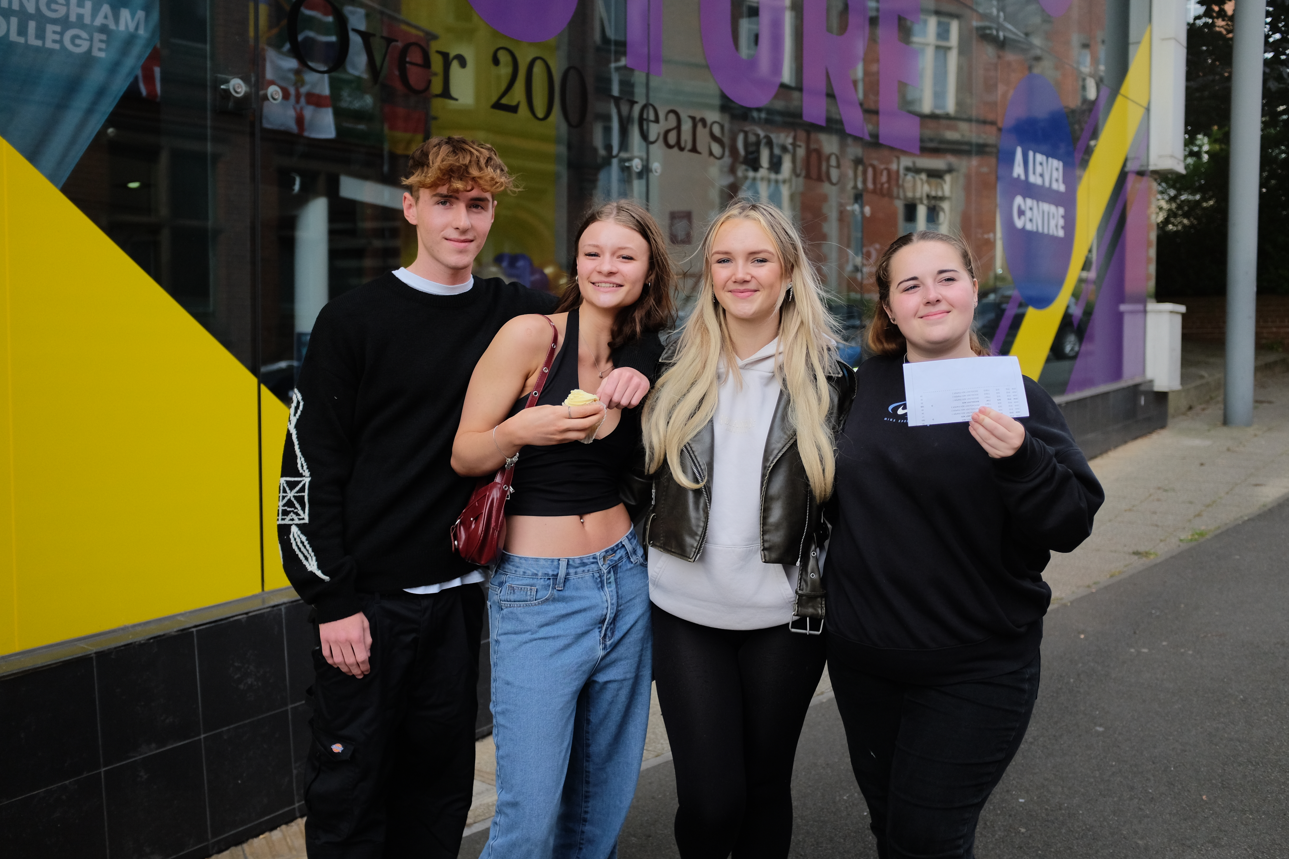 Four students smiling in front of High Pavement