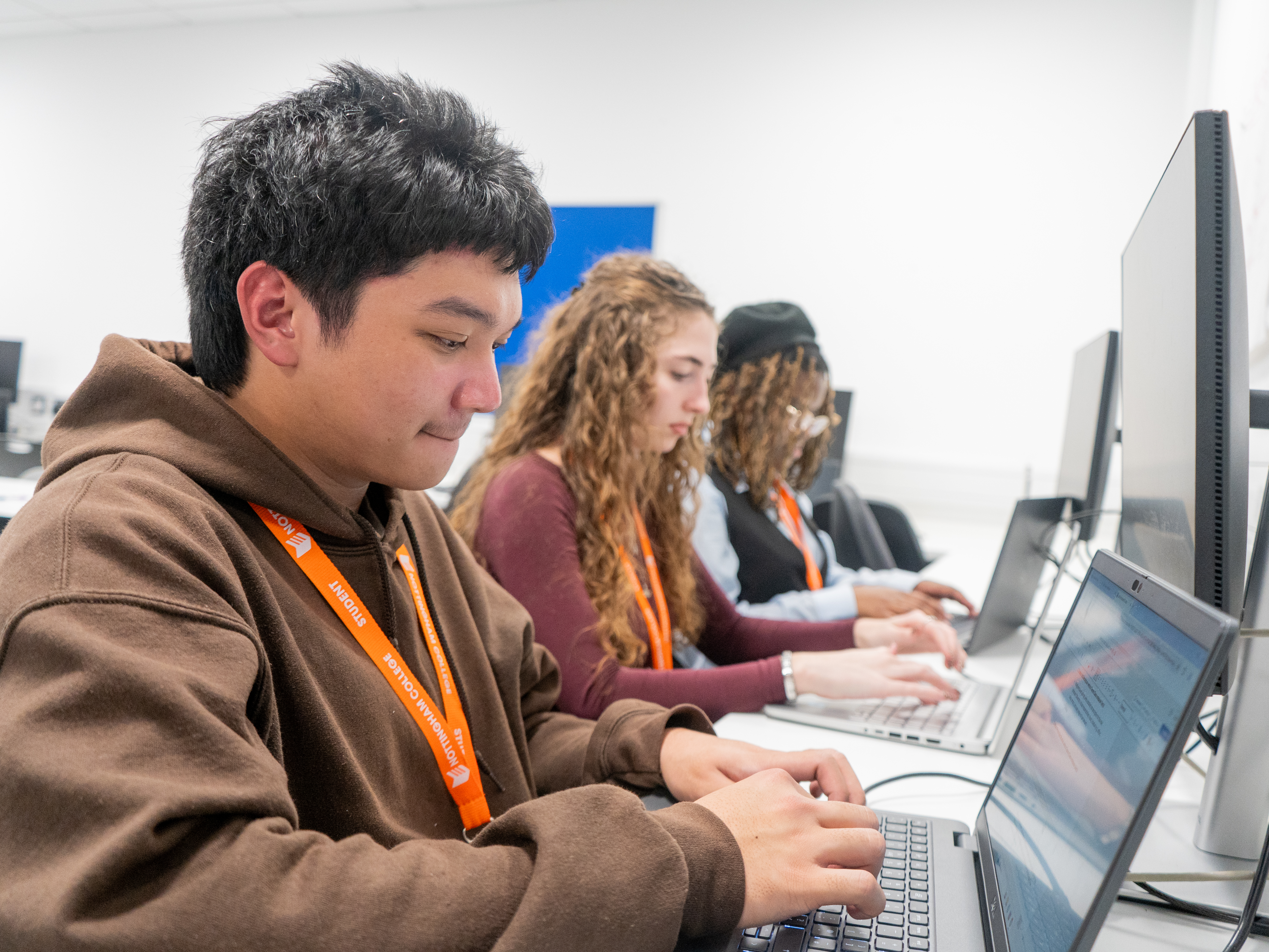 Students working in an IT suite on laptops with screens.