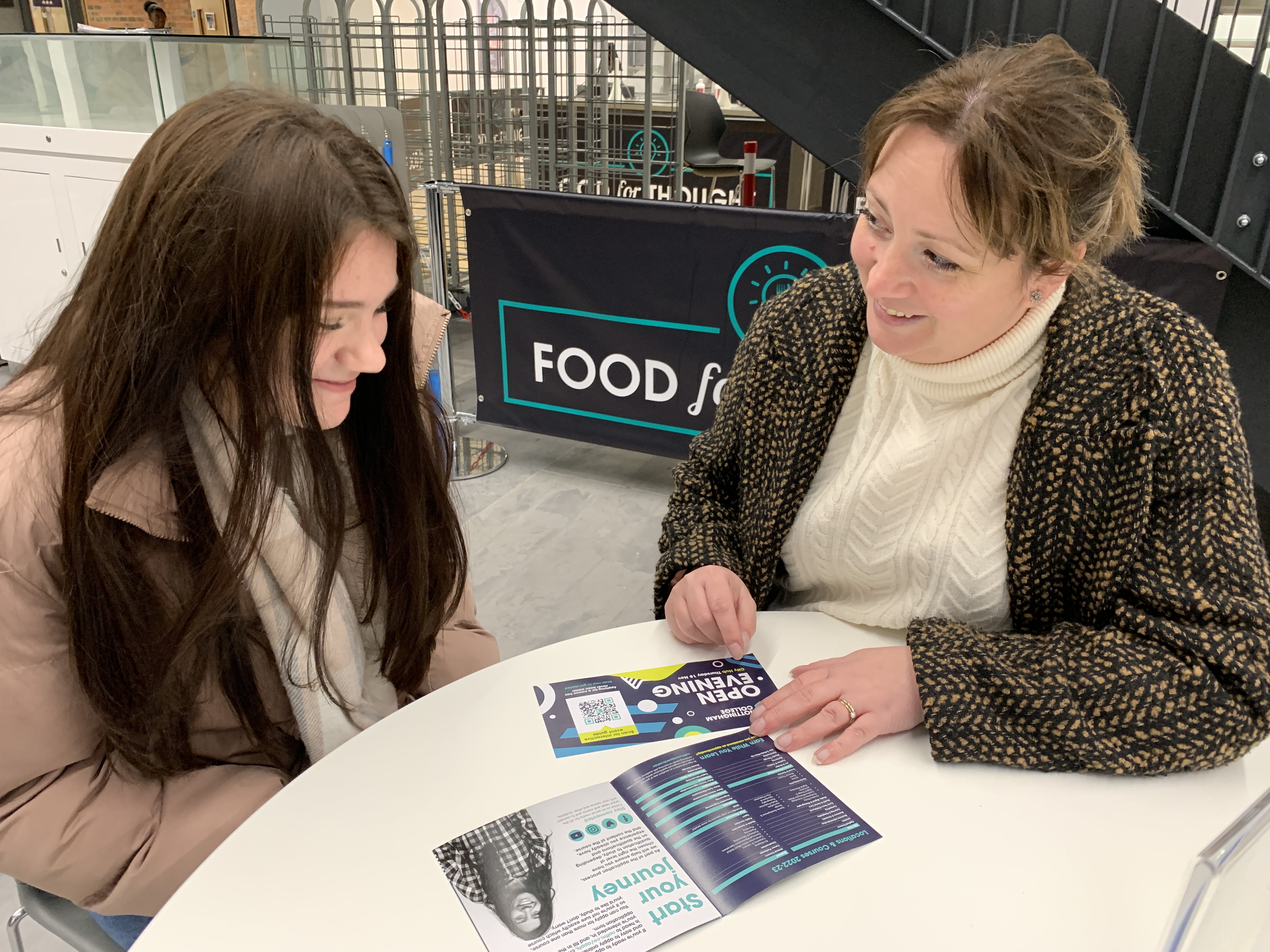 A parent and child discussing options at an Open Evening