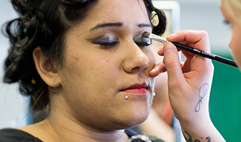 A student applying make up to a client