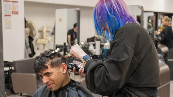 Hairdressing student cutting a client's hair