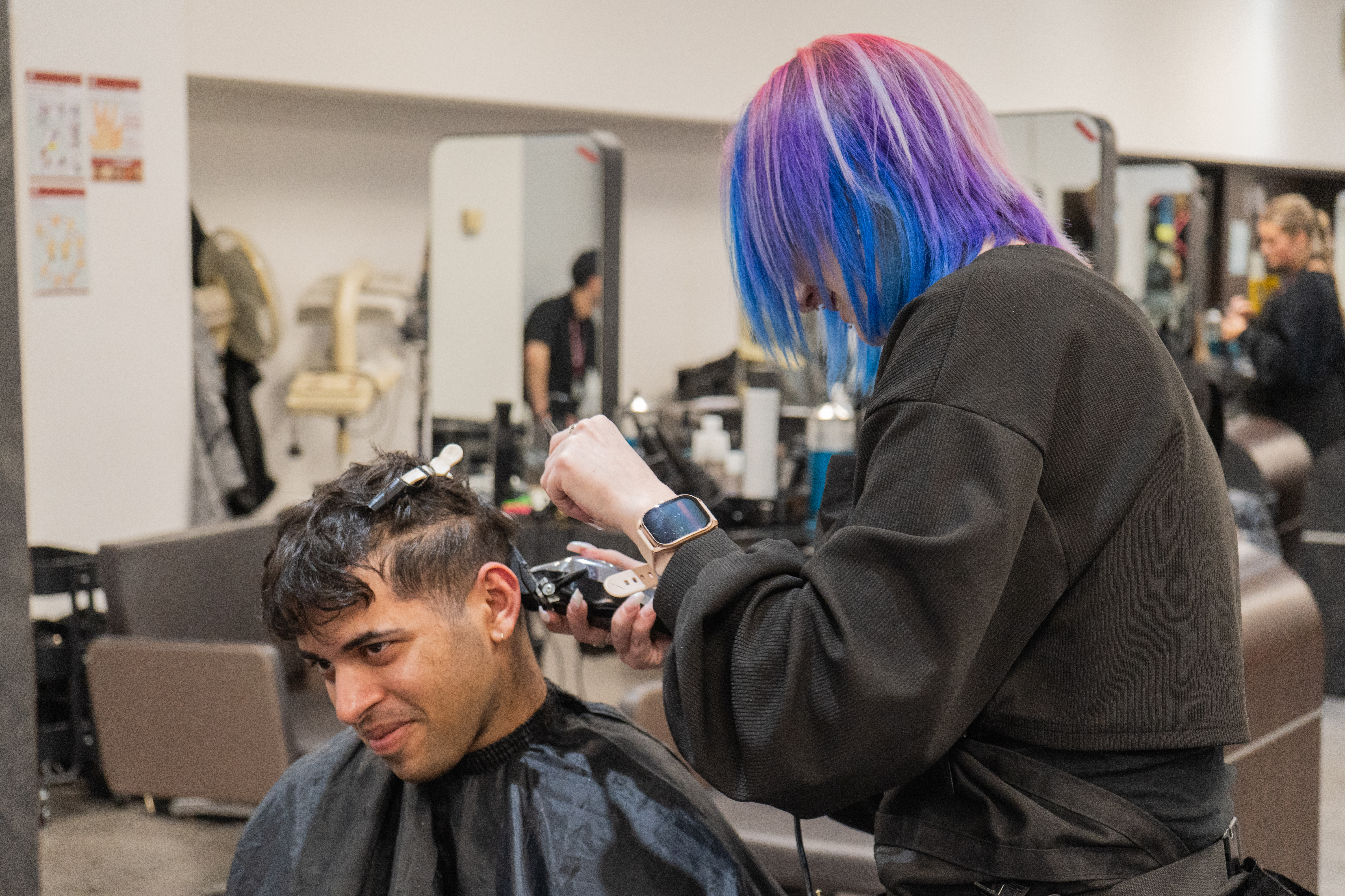 Hairdressing student cutting a client's hair
