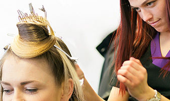 A student styling a clients hair