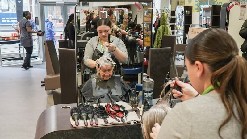 A student styling a client's hair at the Wheeler Gate salon.