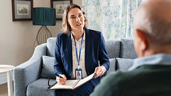 A care worker talking to an elderly person in a care home