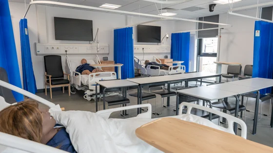 A simulated hospital ward with hospital beds and dummies to practice on.