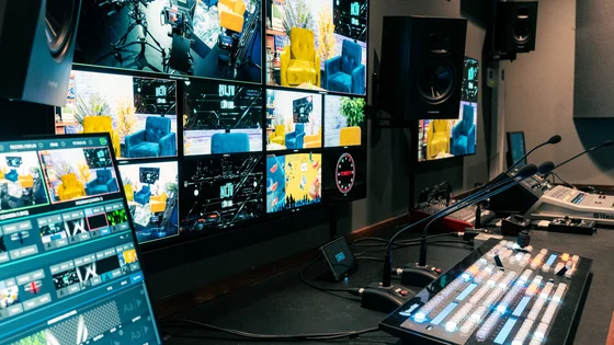 A room containing multiple screens and media equipment for filming