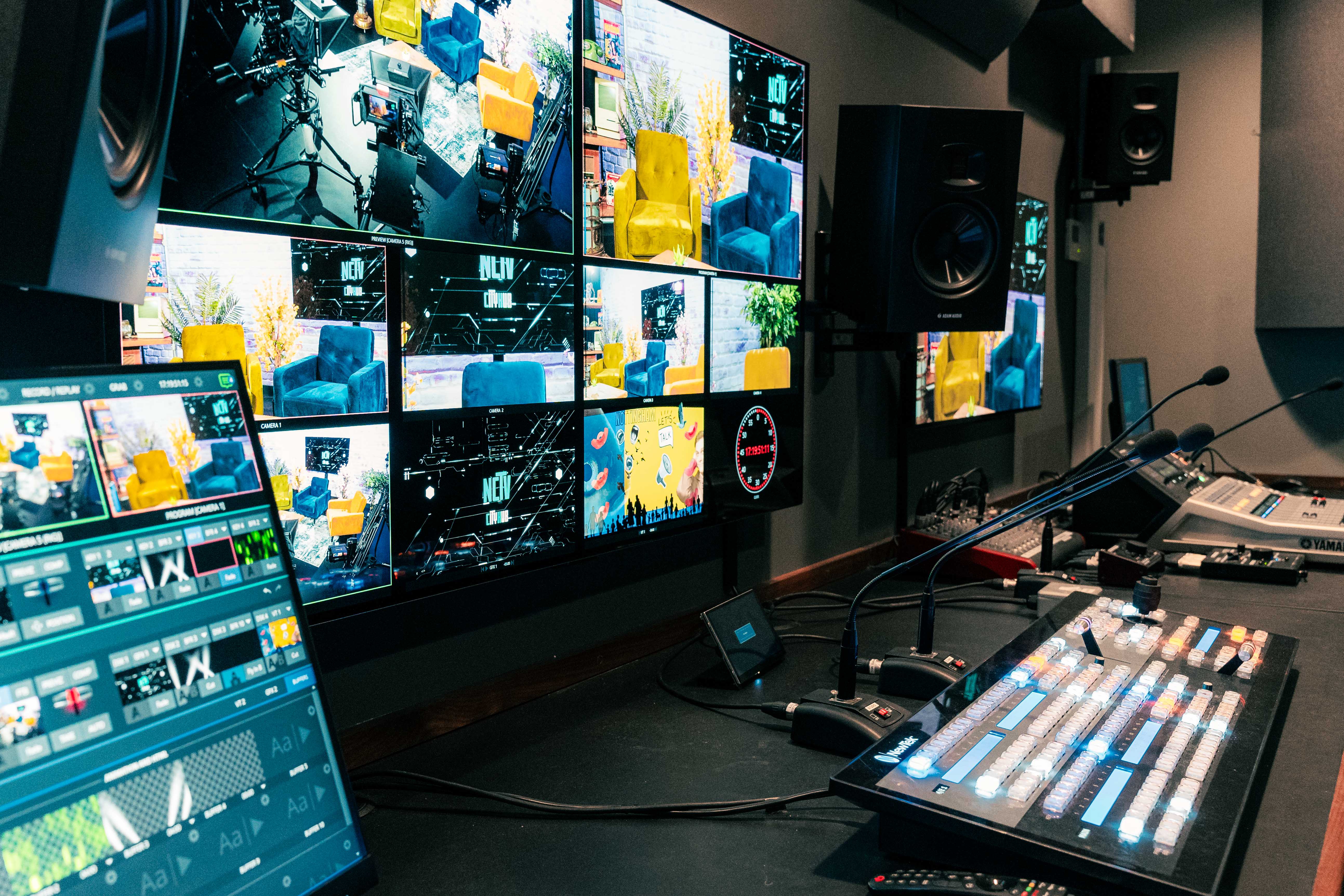 A room containing multiple screens and media equipment for filming